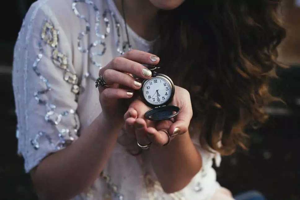 Женщина держит часы